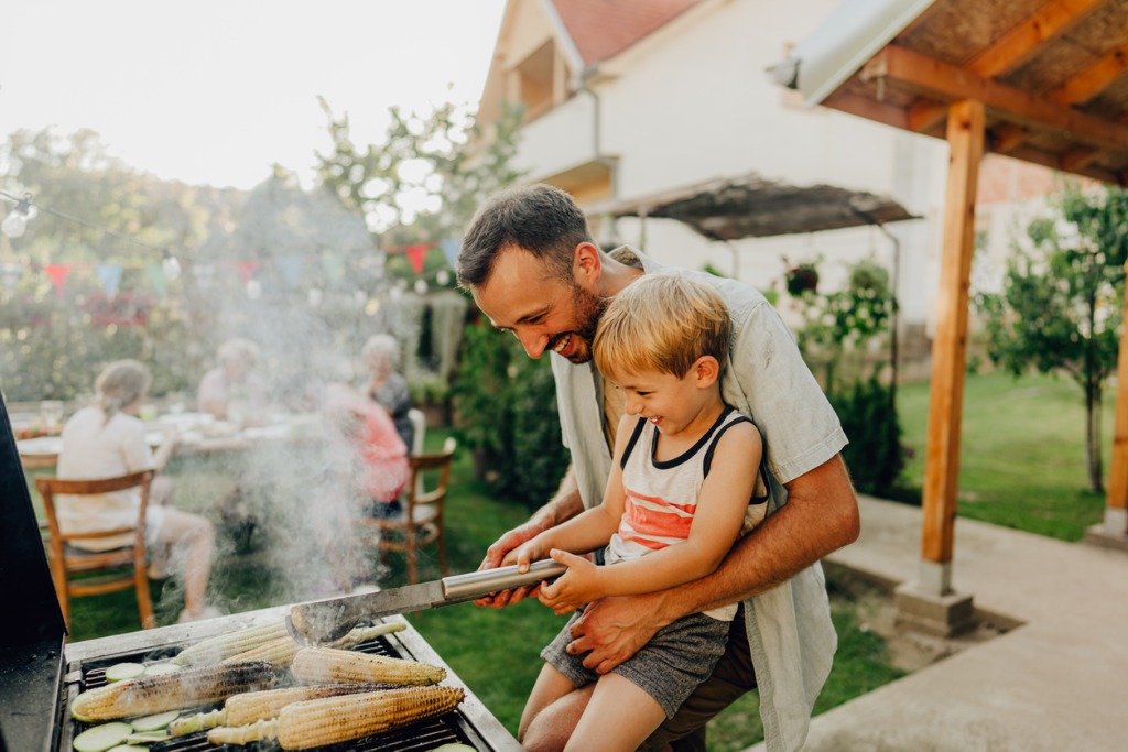 dad-holding-son-grilling-food